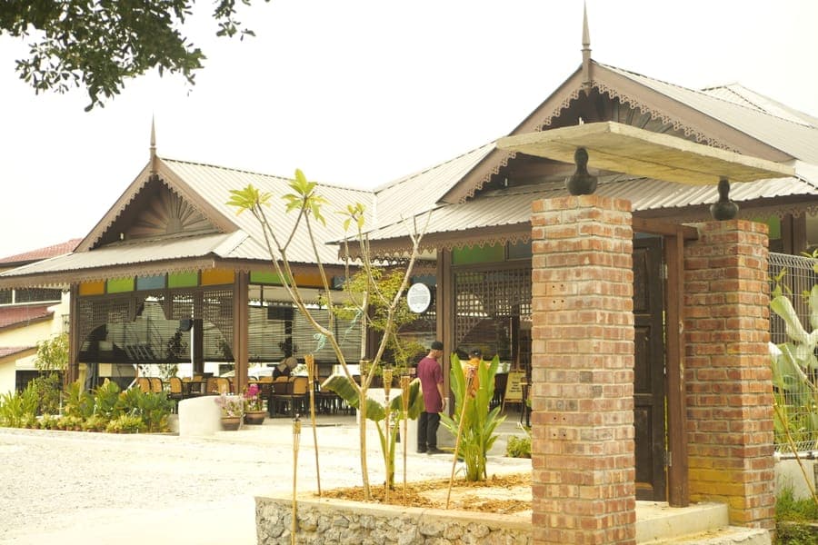 Bangunan restoran berbumbung kampung dengan pokok palma