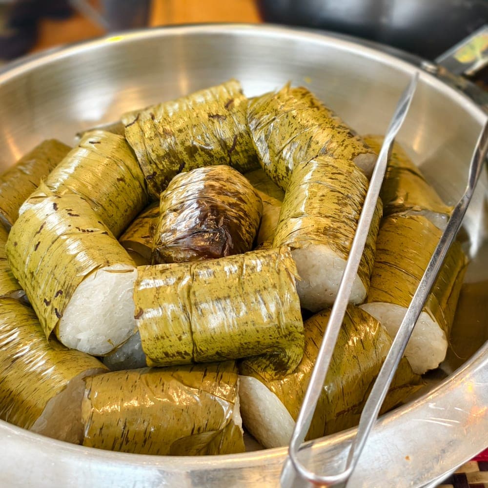 Lemang dibalut daun pisang dihidang dalam dulang