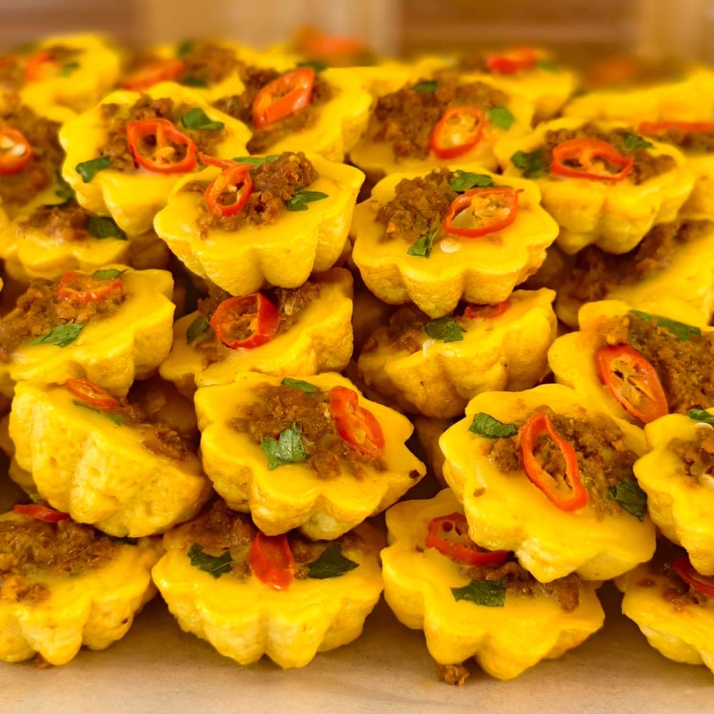 Kuih cara berlauk berbentuk bunga dengan inti dan hirisan cili